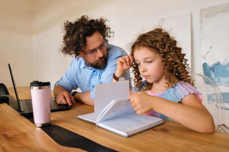 Father Helping Daughter With Homework Using Laptop In a Desk Home Office Together Stay at Home...
