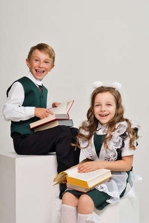 Uniform elementary school students read paper books with interest. Knowledge day. Back to school. Education and study. World Read Aloud Dayの写真素材