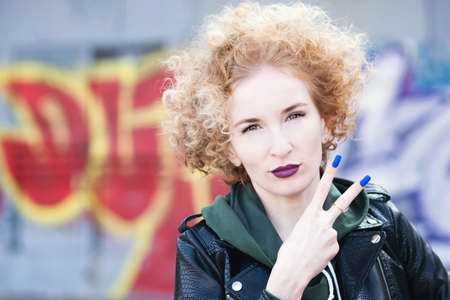 Fashionista girl with afro hairstyle with violet lips in urban. Girl wearing casual clothes posing...
