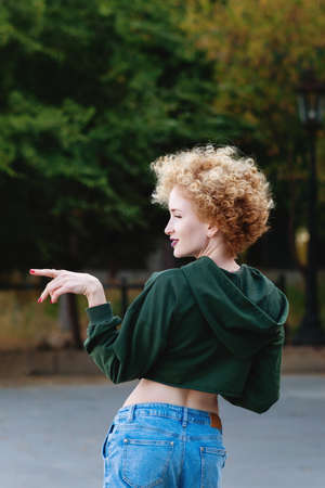 Fashionista girl hipster in green crop top on the street. Trendy urban girl fashion model outdoors. Casual style. Youth, street style, lifestyle, free time conceptの写真素材