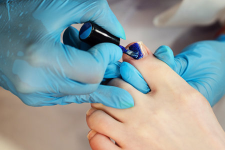Process pedicure close up. Unrecognizable people. Master chiropody applying gel nail polish. Spa. Concept body care.の写真素材