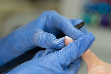 Manicurist Make Shape Nail of Client With Nail File. Professional Nail Care Service. Soft Focus