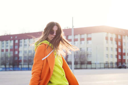 Lifestyle Portrait of cheerful brunette young woman in trendy colorful casual outfit looking over shoulder. Street Style. Good-looking Millennial Hipster Girl having fun sunny outdoorsの写真素材