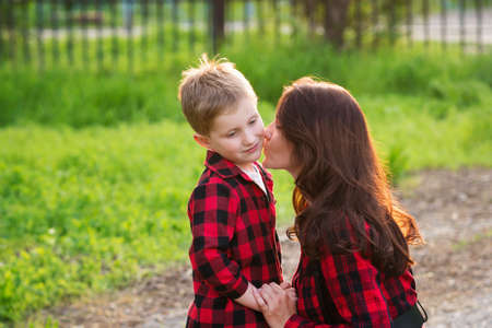 Stylish mom is talking with her naughty son for a walk. Family relationship. Respect and understanding in the familyの写真素材