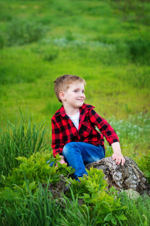 Four year old Caucasian boy in park. Child is mischievous and grimaces at the cameraの写真素材