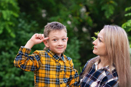 Happy family concept. Beautiful mother and son spending time together in backyard. Having fun. Enjoy summer vacation. Crazy moodの写真素材