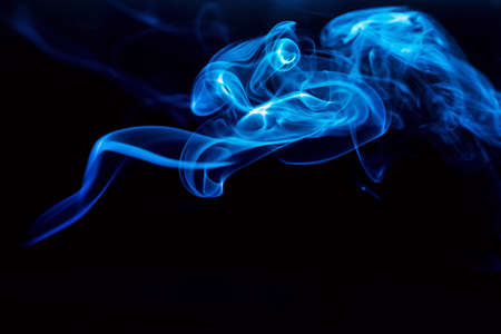 Abstract colored smoke moves on dark background. Wallpaper. Personal vaporizers fragrant steam. Concept of alternative non-nicotine smoking. E-cigarette. Texture. Design elements.の写真素材