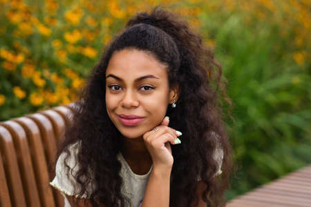 Dark skinned brunette Female with Loose Wavy Curls African American Hair. Outdoor Lifestyle Portrait...