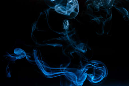 Abstract colored smoke moves on dark background. Wallpaper. Personal vaporizers fragrant steam. Concept of alternative non-nicotine smoking. E-cigarette. Texture. Design elements.の写真素材