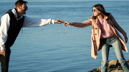 Loving couple walking by sea beach. Happy young lovers outdoors. Lovely hipster couple enjoying...
