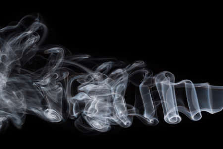 Abstract background of chaotically mixing puffs of smoke on dark background. Concept of alternative non-nicotine smoking. Color smoke on dark background. E-cigarette. Blurry image, soft focus. Vapingの写真素材