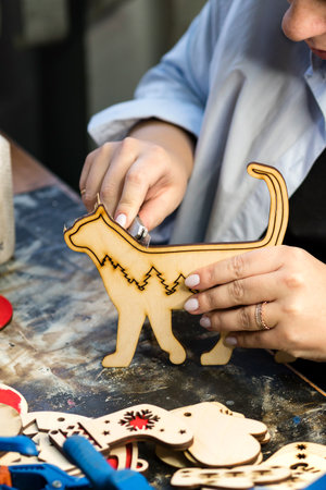 Closeup process making handmade wooden Christmas toys in carpentry woodworking workshop. Eco...
