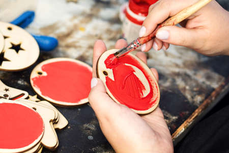 Closeup process making handmade wooden Christmas toys in carpentry woodworking workshop. Eco friendly decor for your home. Sigh symbol Xmas from wood.の写真素材