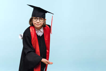 Child Vaccinated. Cute Little Girl pointing finger at adhesive plaster bandage on her arm after Being Injected Covid-19 Vaccine, light blue studio background. children immunization. health passの写真素材