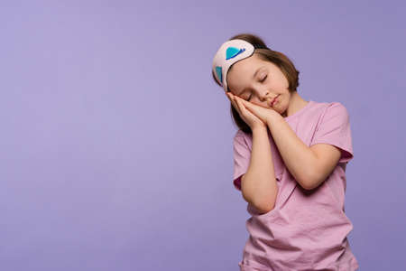 Girl 9-11 yo in basic red t-shirt and yellow headphones looking at cellphone. Child holding German flag and smartphone. Language courses online. Learning Deutsch language. listeningの写真素材