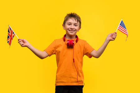 Child play acoustic Ukulele guitar on yellow background. Hawaiian small guitar. Concept of Music Education and Training Practice in Music Schoolの写真素材