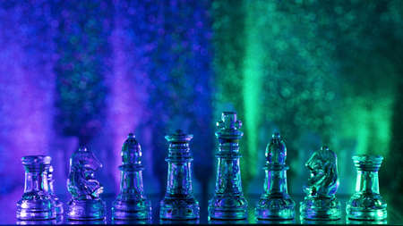 Transparent translucent pieces are placed on chessboard. Concept learning game of chess. Rook Selective Focus. Beautiful back light background in cold colors for advertising. Tactics and strategyの写真素材