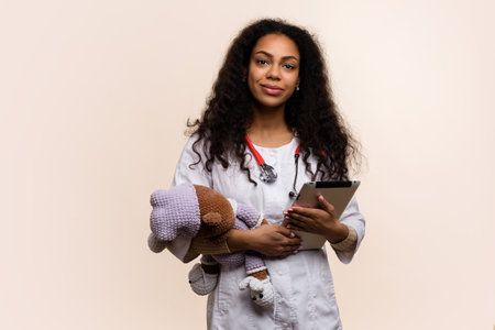 Dark-skinned Female Nurse in Pink Uniform holds Horizontal Banner Blank Ad Space on Blue Background. Specialist Intern Woman General Practitioner Points Index finger at Space for Advertisementの写真素材