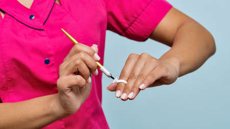 Portrait Non-Caucasian Skinned Woman Master Beautician of Eyebrow Tattooing on Blue Background....