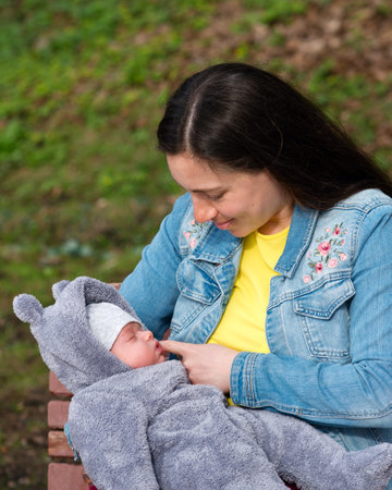 Close Up Young Happy Mom with Newborn Son on Nature Outdoors. Loving Mother and New Born Child on...
