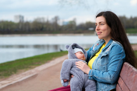 Close Up Young Happy Mom with Newborn Son on Nature Outdoors. Loving Mother and New Born Child on...