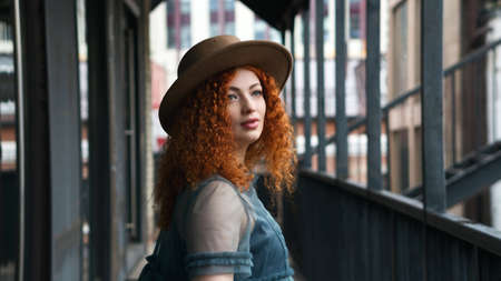 Girl wears Retro Vintage Gray Airy Dress and Felt Hat Walks in Evening Rain through City Street....