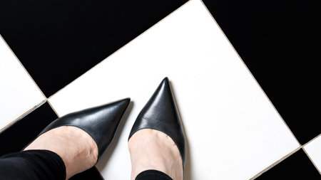 Selfie feet wears classic shoes court shoe on checkered floor background. Image legs in red velvet...