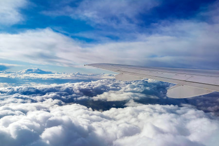 Beautiful aerial view seen through window of flying airplane. Scenic view of cloudy sky from...