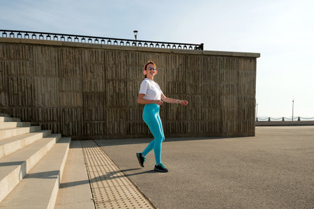 Woman jogging or running. Female athlete in sportswear does fitness activities outdoors. Healthy...