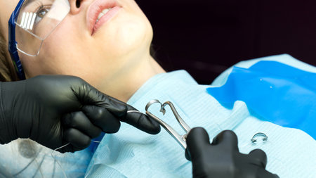 Dentist or his assistant is ready to install metal clips before tooth restoration procedureの写真素材