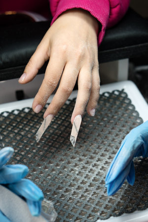 Expert manicurist files edge nails with precision.の写真素材