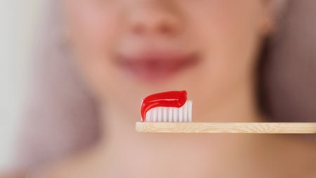 Close-up of red toothpaste on bamboo brush. Oral health conceptの写真素材