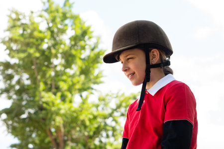 Young equestrian smiling during outdoor riding session. Riding schoolの写真素材