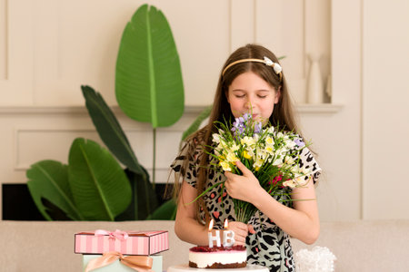 A girl with a bouquet of flowers, looking thoughtful during her birthday celebration. Portrait of a Beautiful Birthday Girlの写真素材