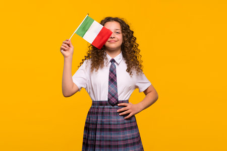Girl posing with Italian flag, hand on hip, proud expression. Foreign language learning concept.の写真素材