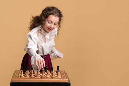 Young girl smiling while adjusting chess pieces on the board.の写真素材