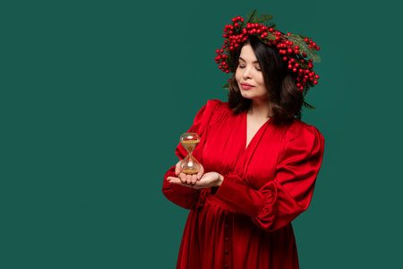 Elegant woman in red dress holding hourglass with closed eyes.の写真素材