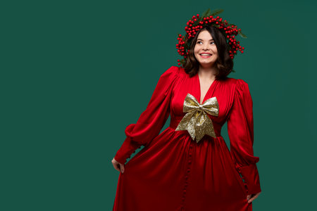 Smiling woman in red dress with gold bow posing playfully.