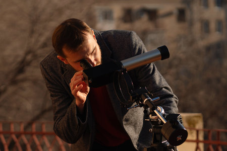 A dedicated observer inspects solar activity with a rooftop telescopeの写真素材