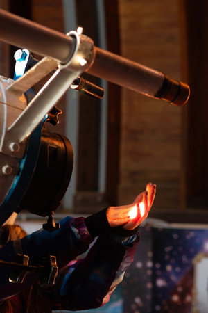 Gloved hand catching bright telescope light in an observatory. The projection of the solar disk on...