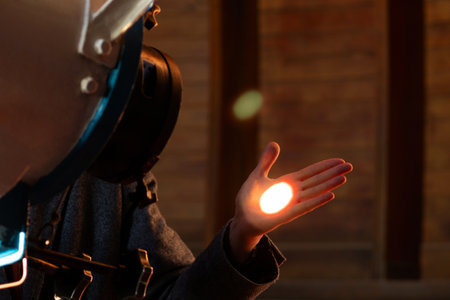 Man's hand illuminated by a focused telescope light beam. The projection of the solar disk on the palmの写真素材