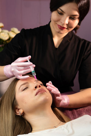 Aesthetician preparing nonâsurgical forehead care for skin renewal. Biorevitalization peel for women at cosmetology clinic.の写真素材