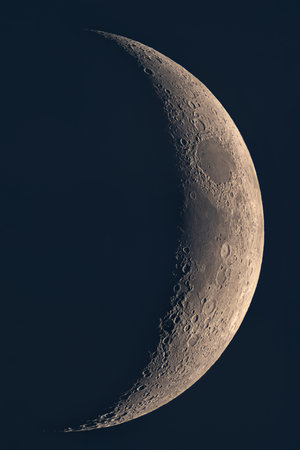 Panoramic view of crescent Moon terminator with detailed craters. High-Resolution Moon's Terminator Line with Craters and smooth lunar maria under low-angle sunlight.の写真素材
