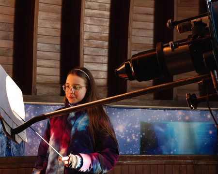 Girl examines a projected solar image inside an observatory. Education, teaching, learning conceptの写真素材