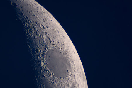 High-resolution image shows dark-floored crater on crescent Moon limb. Background for book covers, digital backgrounds, science blogs and educational posters in the astronomy niche.の写真素材