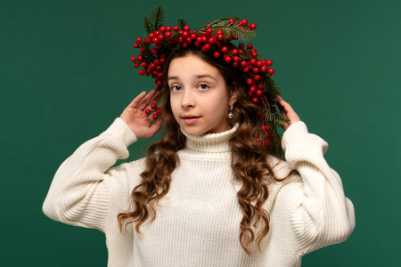 Girl wearing a wreath of red berries and green fir branches.の写真素材