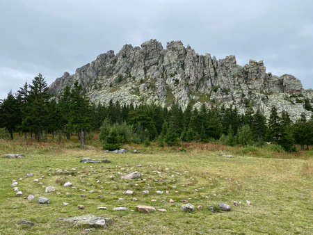May meadows. View of the Otkliknoy ridge. The hand made spiral of stones on the grass. The popular tourist destination. Taganay national Park. Zlatoust city. Chelyabinsk region. South Ural. Russia.の写真素材