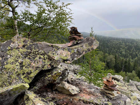 Small pyramids made of stones. View of the Otkliknoy ridge. The pyramids are made by hands and serve as pointers of the way. Taganay national Park. Zlatoust city. Chelyabinsk region. South Ural.の写真素材