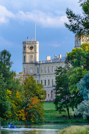 An ancient Palace in the Gatchina Palace Park on the shore of the lake against the blue sky and clouds.のeditorial素材