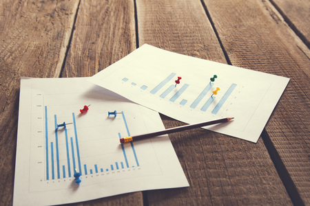 Workplace on wooden table with graph papersの写真素材